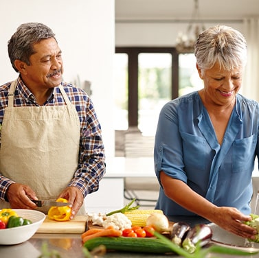 An older couple cooking healthy foods at home