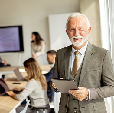 A senior business man working on a digital tablet in the office