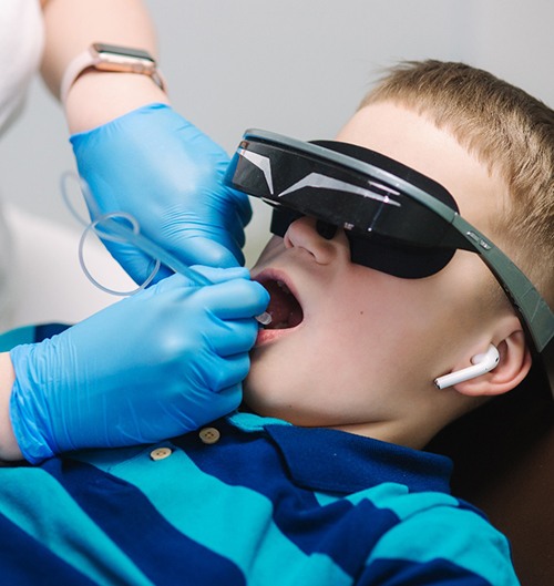 A little boy pointing to his tooth