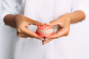 Close up of dentist holding a pair of dentures