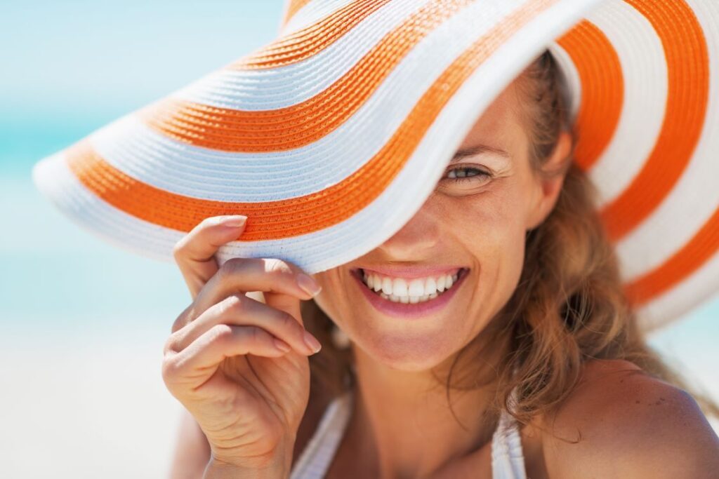 A woman wearing a sun hat and smiling.